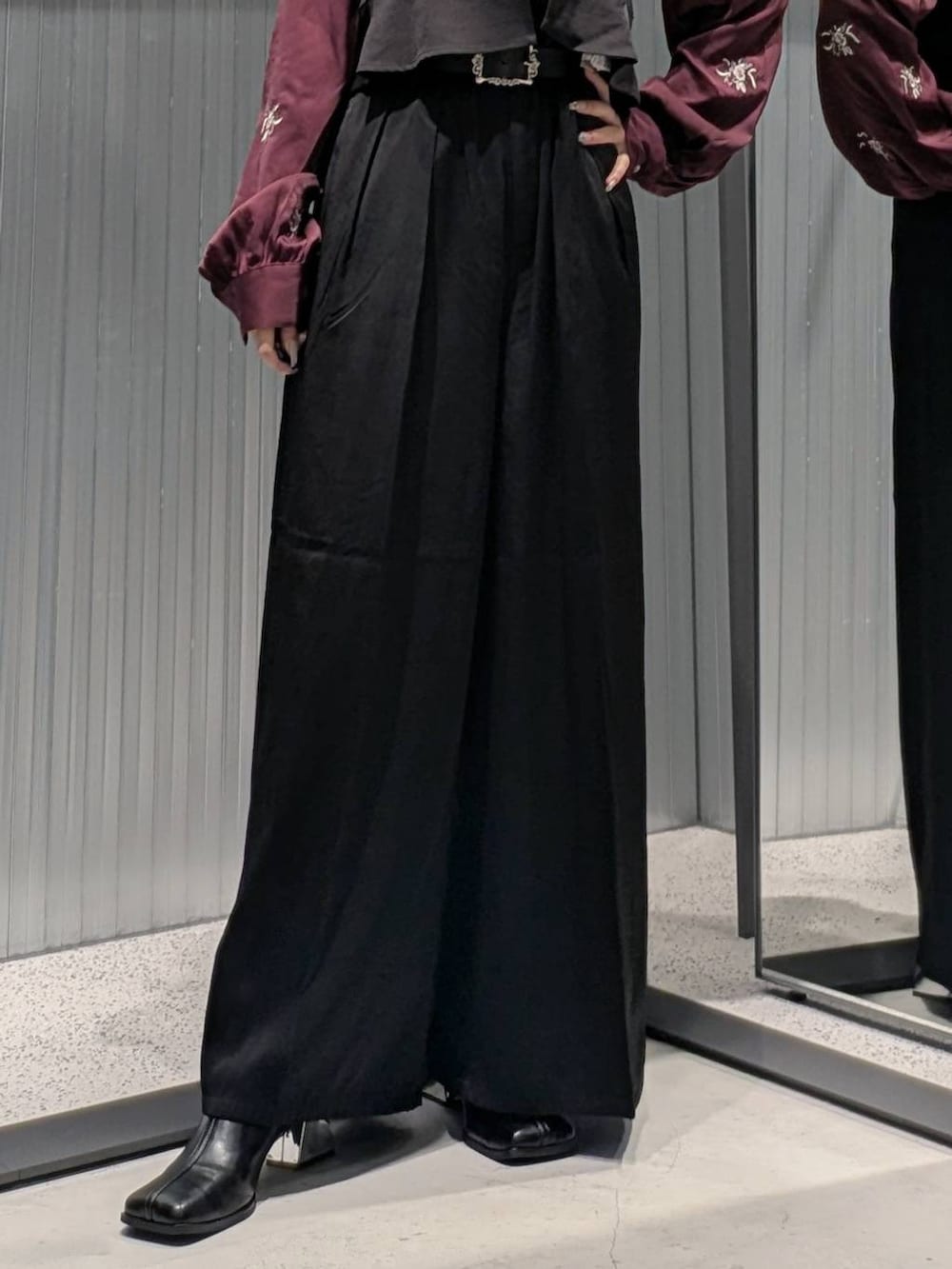 レッド系のシャツ/ブラウス、ブラック系のその他パンツ、ブラック系のブーツを着用したレディースの秋コーディネートの3枚目の写真