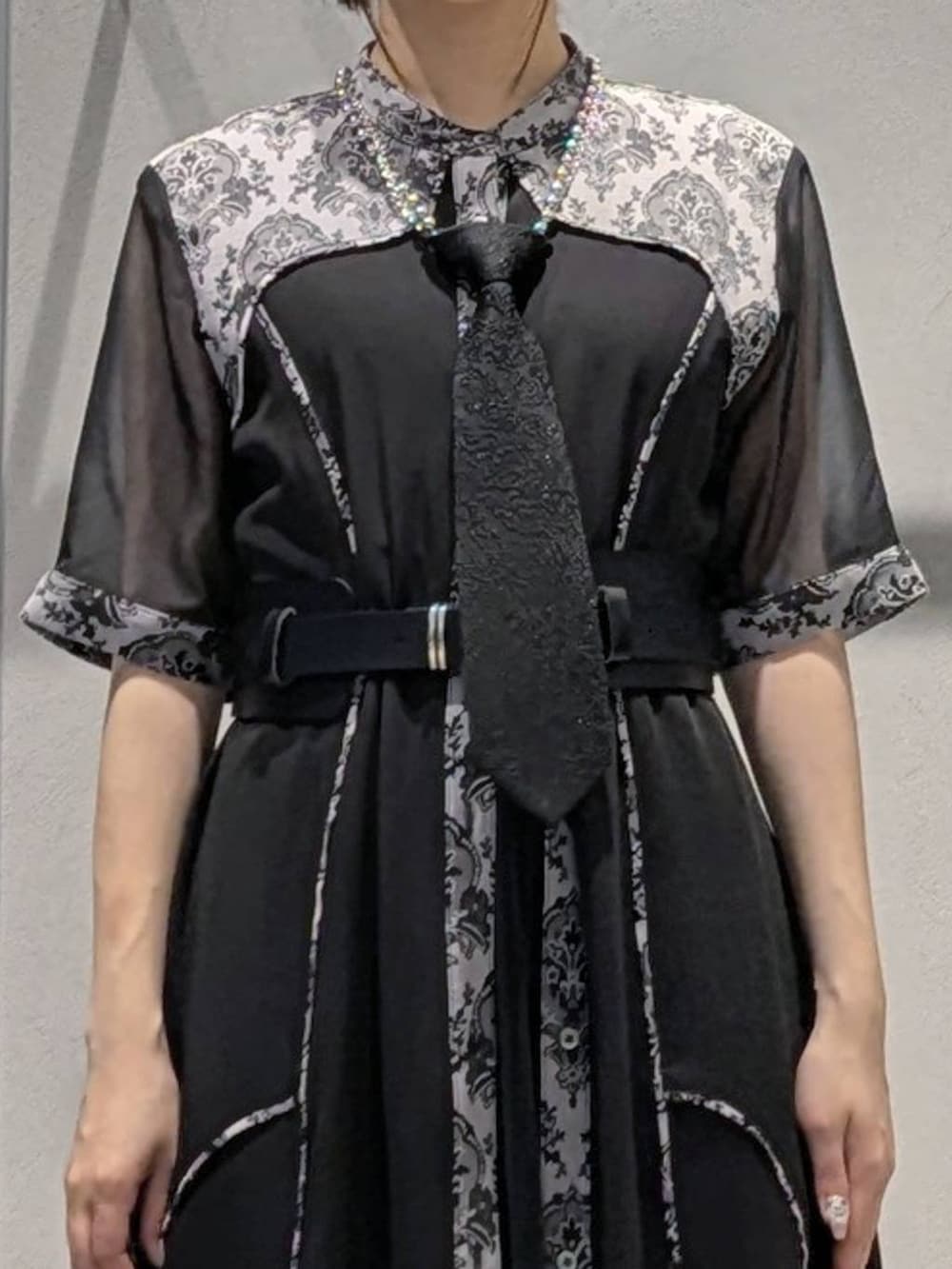 ブラック系のネクタイ、ブラック系のサンダル、ブラック系のワンピースを着用したレディースの夏コーディネートの2枚目の写真