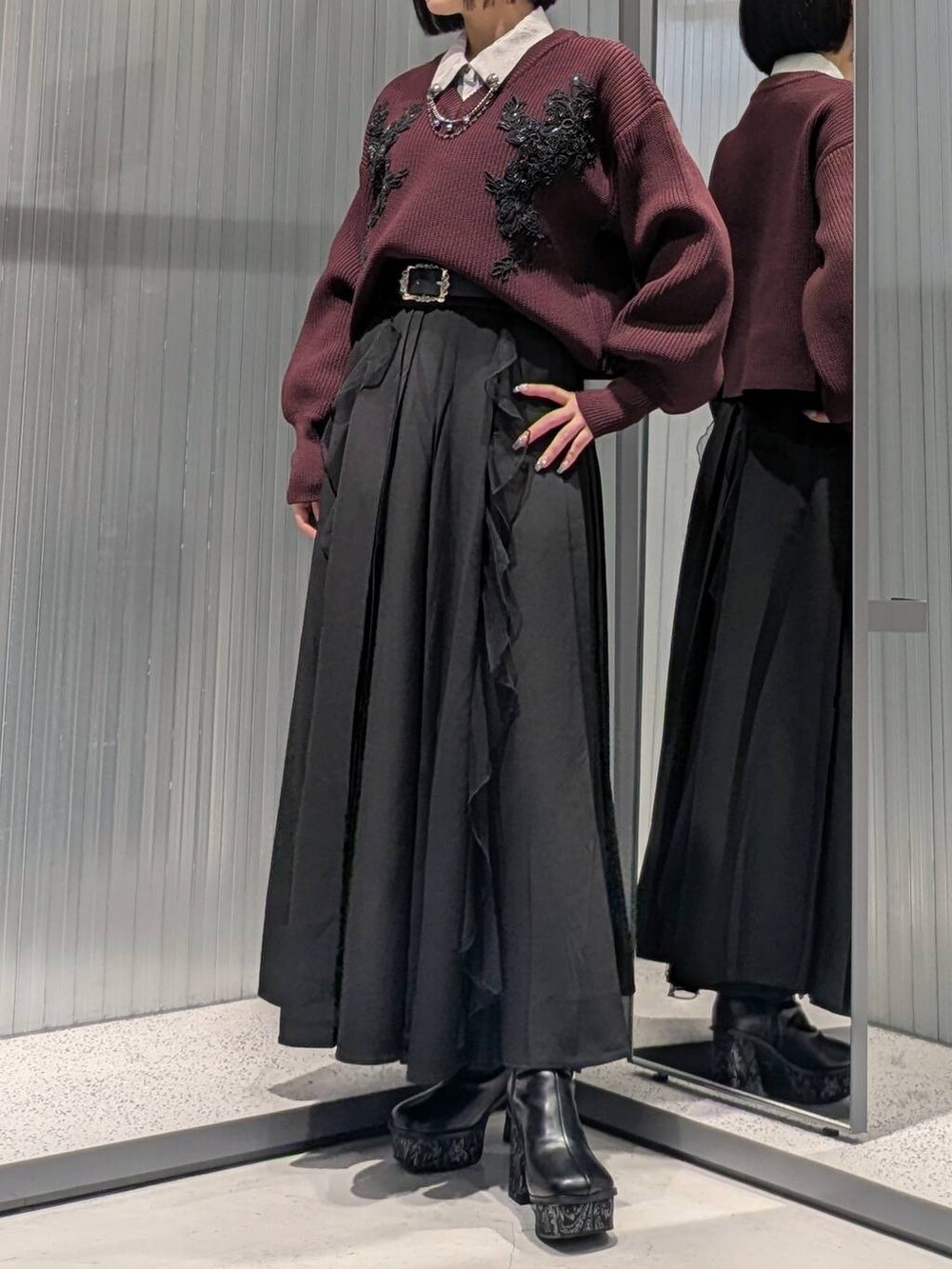 ブラック系のスカート、グレー系のブーツ、レッド系のニット/セーターを着用したレディースの秋コーディネートの4枚目の写真