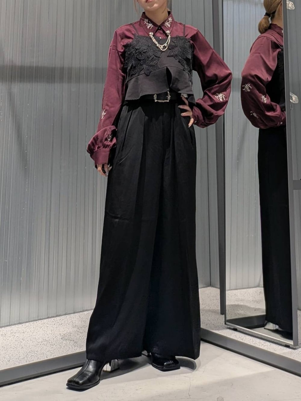 レッド系のシャツ/ブラウス、ブラック系のその他パンツ、ブラック系のブーツを着用したレディースの秋コーディネートの4枚目の写真