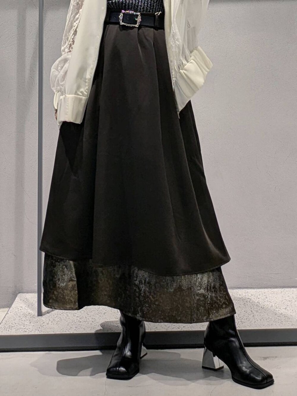 ブラック系のタンクトップ、ホワイト系のブルゾン、ブラック系のブーツを着用したレディースの夏コーディネートの3枚目の写真