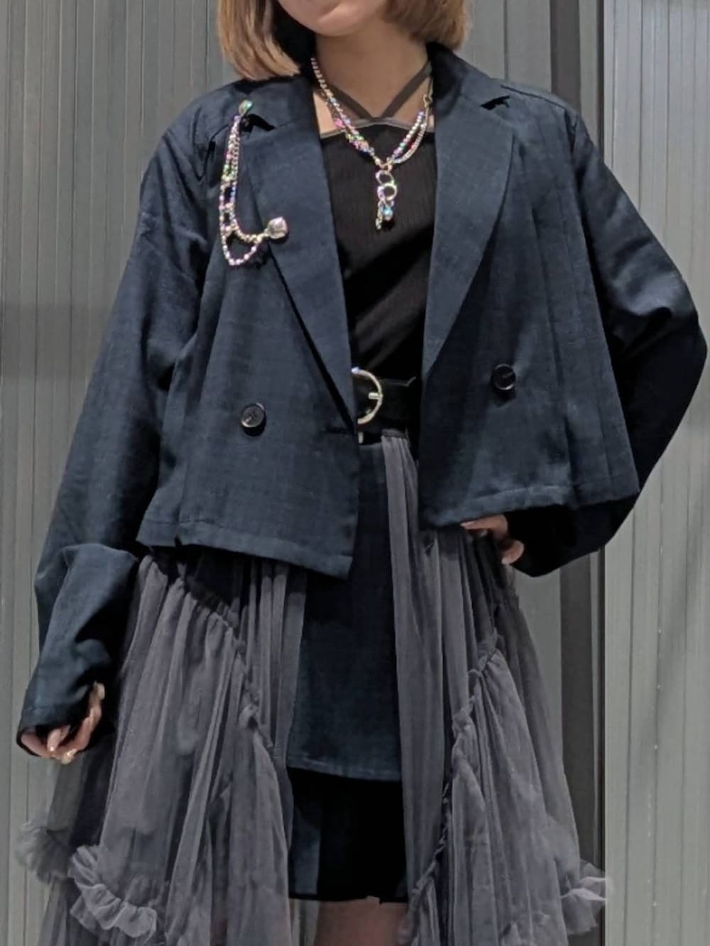 ブラック系のサンダル、グレー系のスカート、ブラック系のTシャツ/カットソーを着用したレディースの夏コーディネートの2枚目の写真