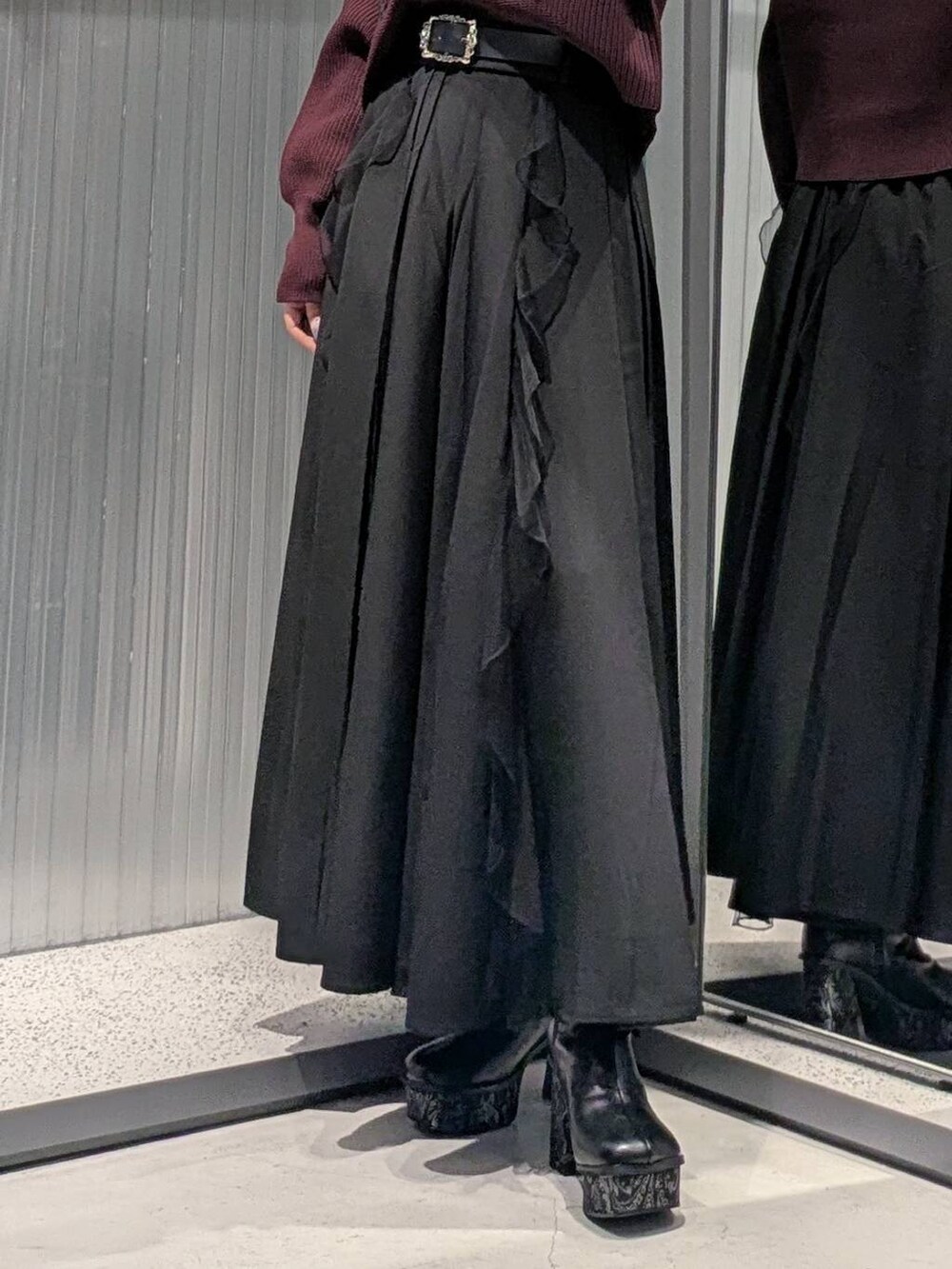 ブラック系のスカート、グレー系のブーツ、レッド系のニット/セーターを着用したレディースの秋コーディネートの3枚目の写真