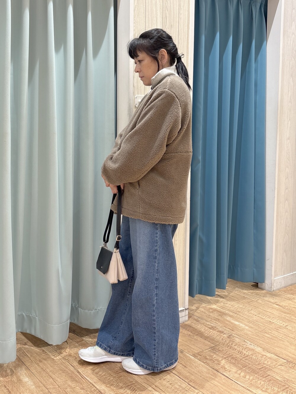 ブラウン系のブルゾン、ブラウン系のTシャツ/カットソー、ホワイト系のスウェットを着用したレディースの秋コーディネートの2枚目の写真