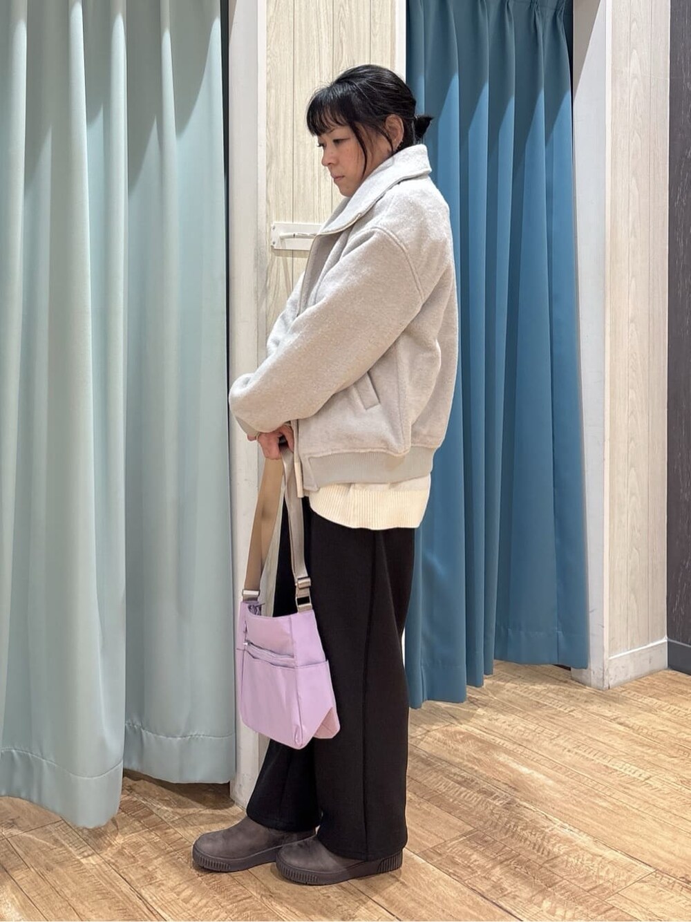 グレー系のブルゾン、ホワイト系のニット/セーター、ブラック系のTシャツ/カットソーを着用したレディースの冬コーディネートの2枚目の写真