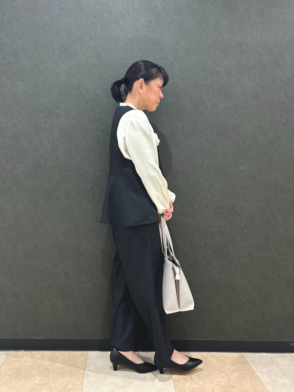 ブラック系のベスト、ホワイト系のシャツ/ブラウス、ブラック系のその他パンツを着用したレディースの冬コーディネートの2枚目の写真