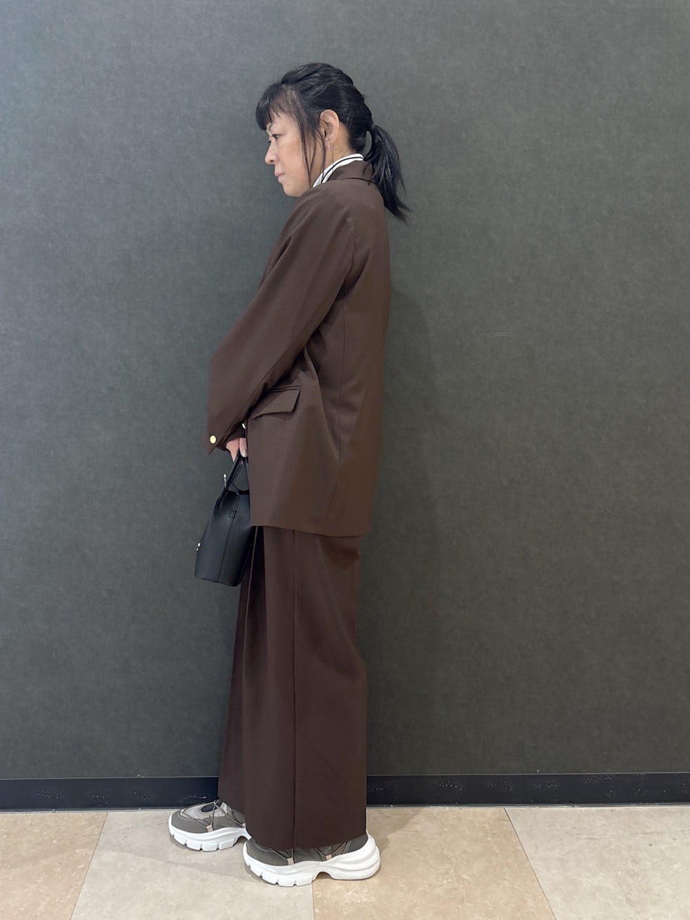 ブラウン系のテーラードジャケット、ブラック系のTシャツ/カットソー、ブラウン系のその他パンツを着用したレディースの秋コーディネートの2枚目の写真