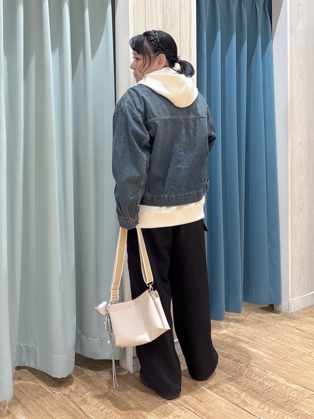 ブルー系のデニムジャケット、ホワイト系のパーカー、ブラック系のTシャツ/カットソーを着用したレディースの冬コーディネートの3枚目の写真