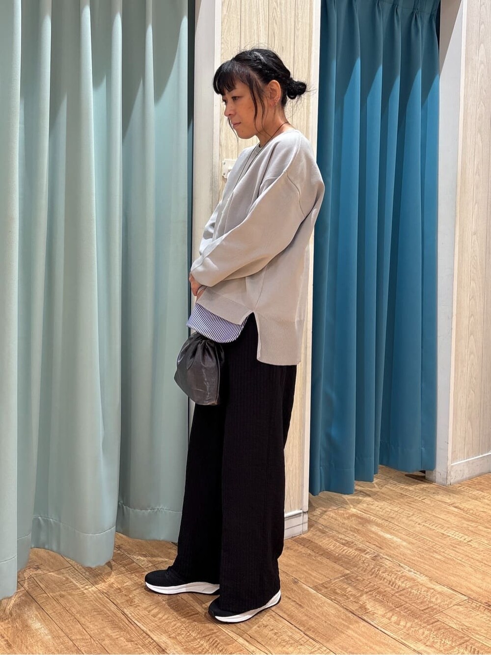 グレー系のニット/セーター、ブラック系のその他パンツ、ブラック系のスニーカーを着用したレディースの秋コーディネートの2枚目の写真
