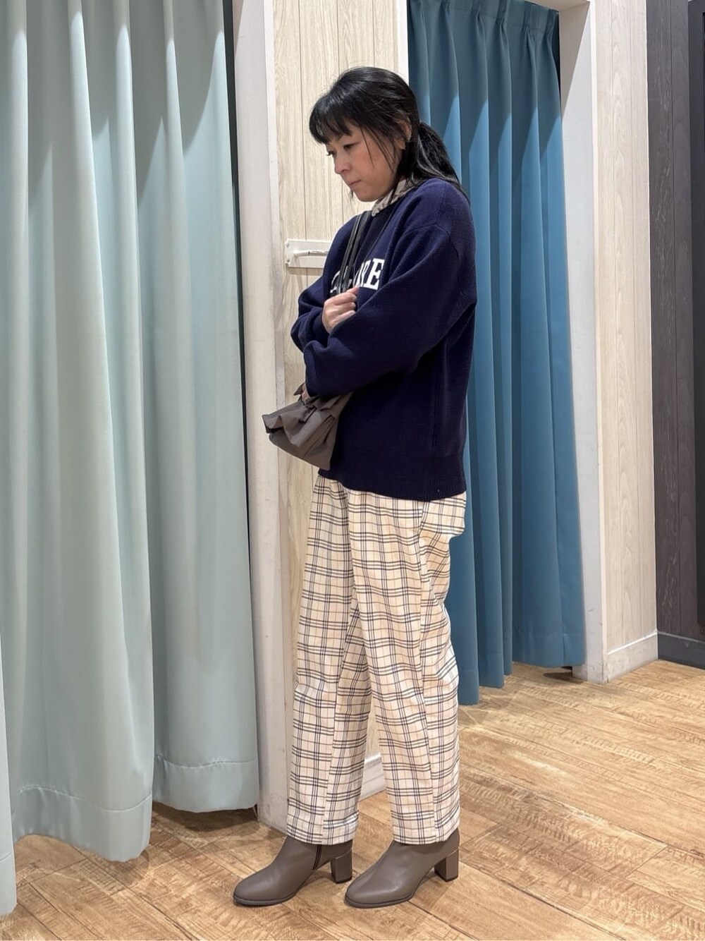 ブルー系のニット/セーター、ベージュ系のTシャツ/カットソー、グレー系のその他パンツを着用したレディースの冬コーディネートの2枚目の写真
