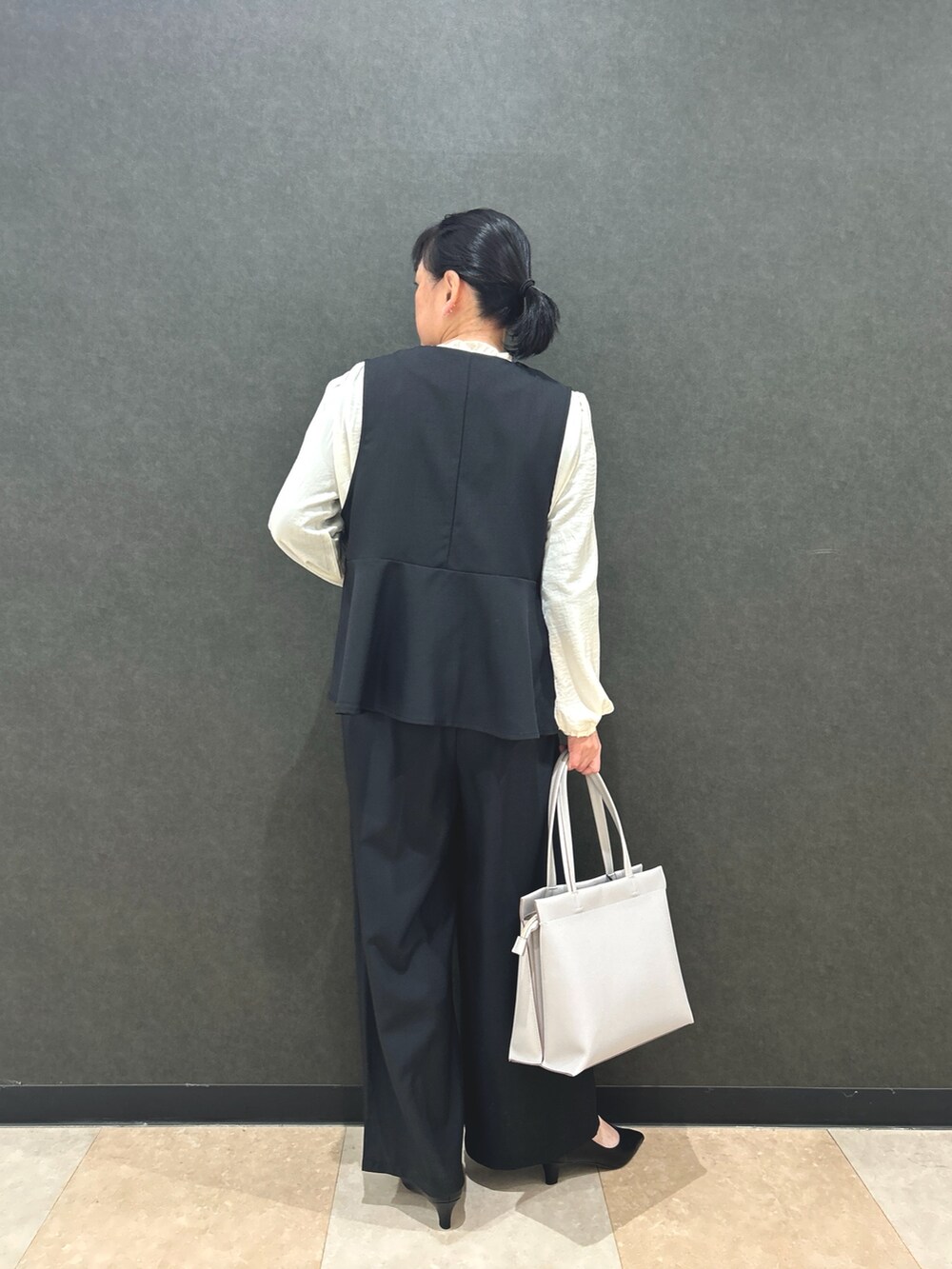 ブラック系のベスト、ホワイト系のシャツ/ブラウス、ブラック系のその他パンツを着用したレディースの冬コーディネートの3枚目の写真