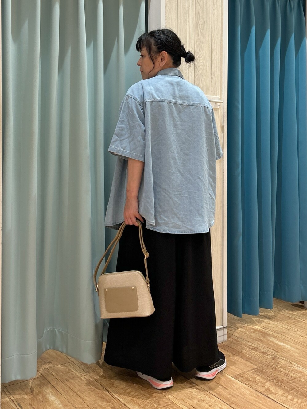 ブラック系のサロペット/オーバーオール、ブルー系のシャツ/ブラウス、ホワイト系のTシャツ/カットソーを着用したレディースの夏コーディネートの3枚目の写真