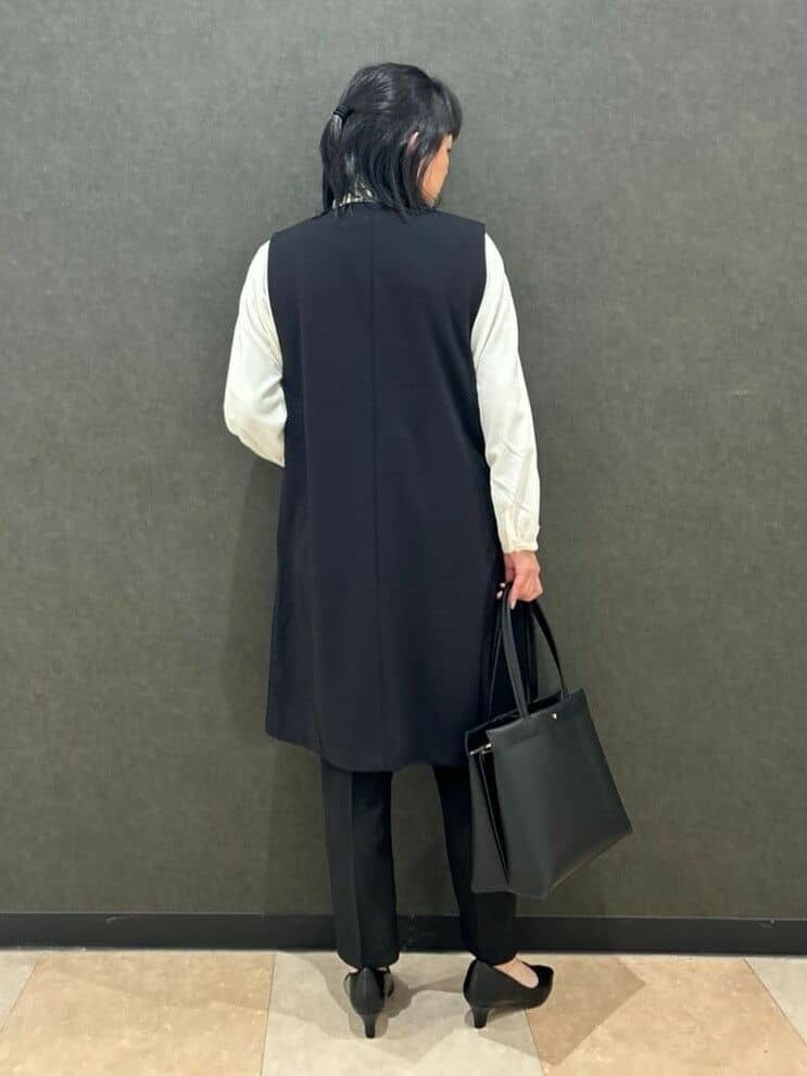 ブラック系のベスト、ホワイト系のシャツ/ブラウス、ブラック系のその他パンツを着用したレディースの冬コーディネートの3枚目の写真