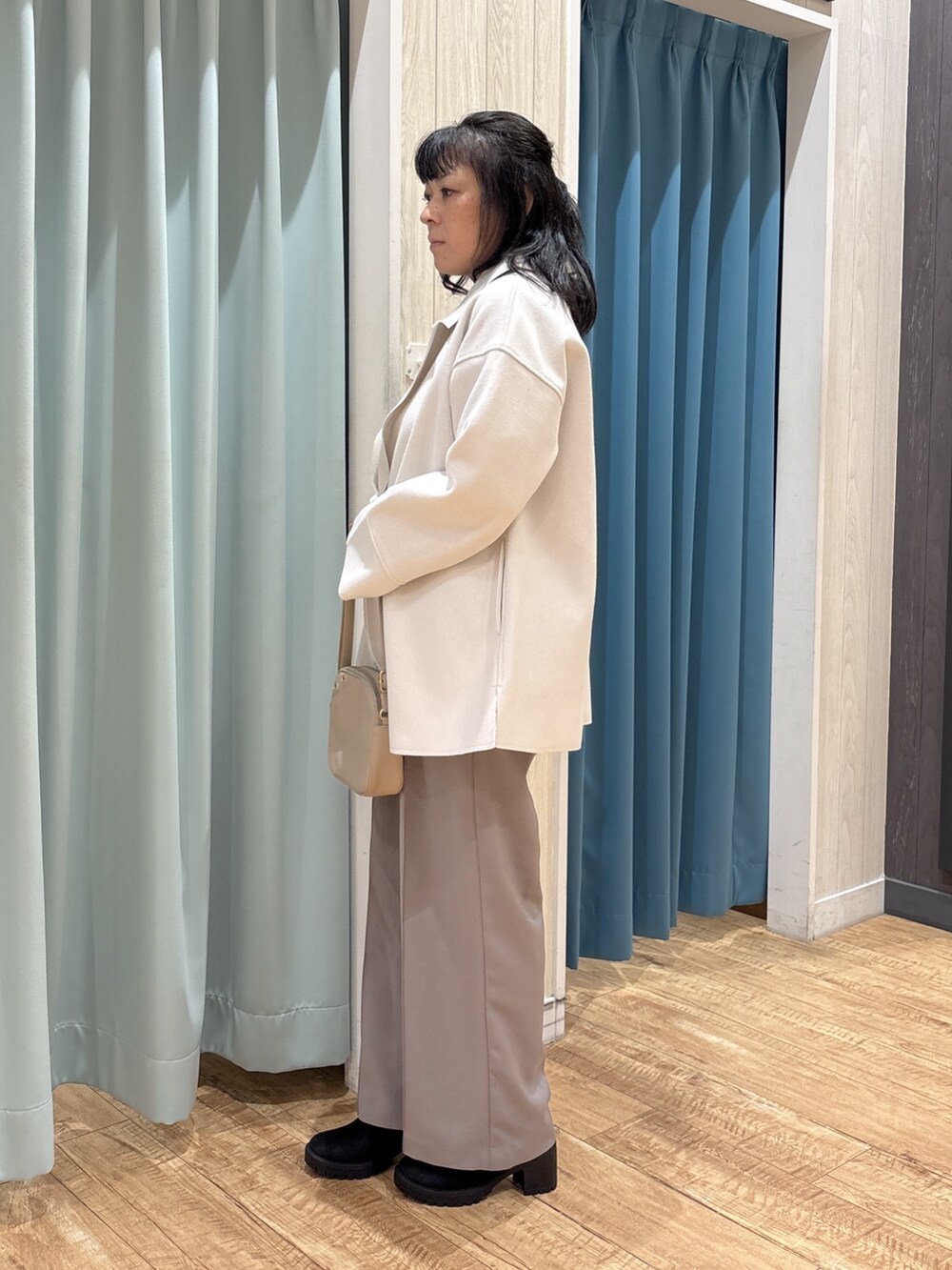 ホワイト系のテーラードジャケット、グリーン系のニット/セーター、グレー系のその他パンツを着用したレディースの秋コーディネートの2枚目の写真