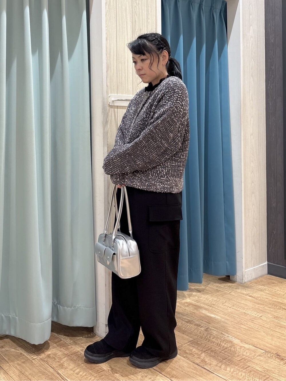 シルバー系のボストンバッグ、ブラック系のその他パンツ、グレー系のカーディガン/ボレロを着用したレディースの冬コーディネートの2枚目の写真