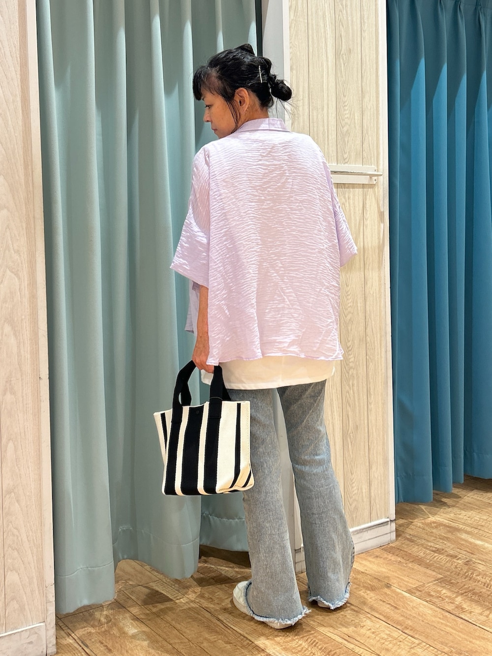 パープル系のシャツ/ブラウス、ホワイト系のチュニック、ブルー系のデニムパンツを着用したレディースの夏コーディネートの3枚目の写真
