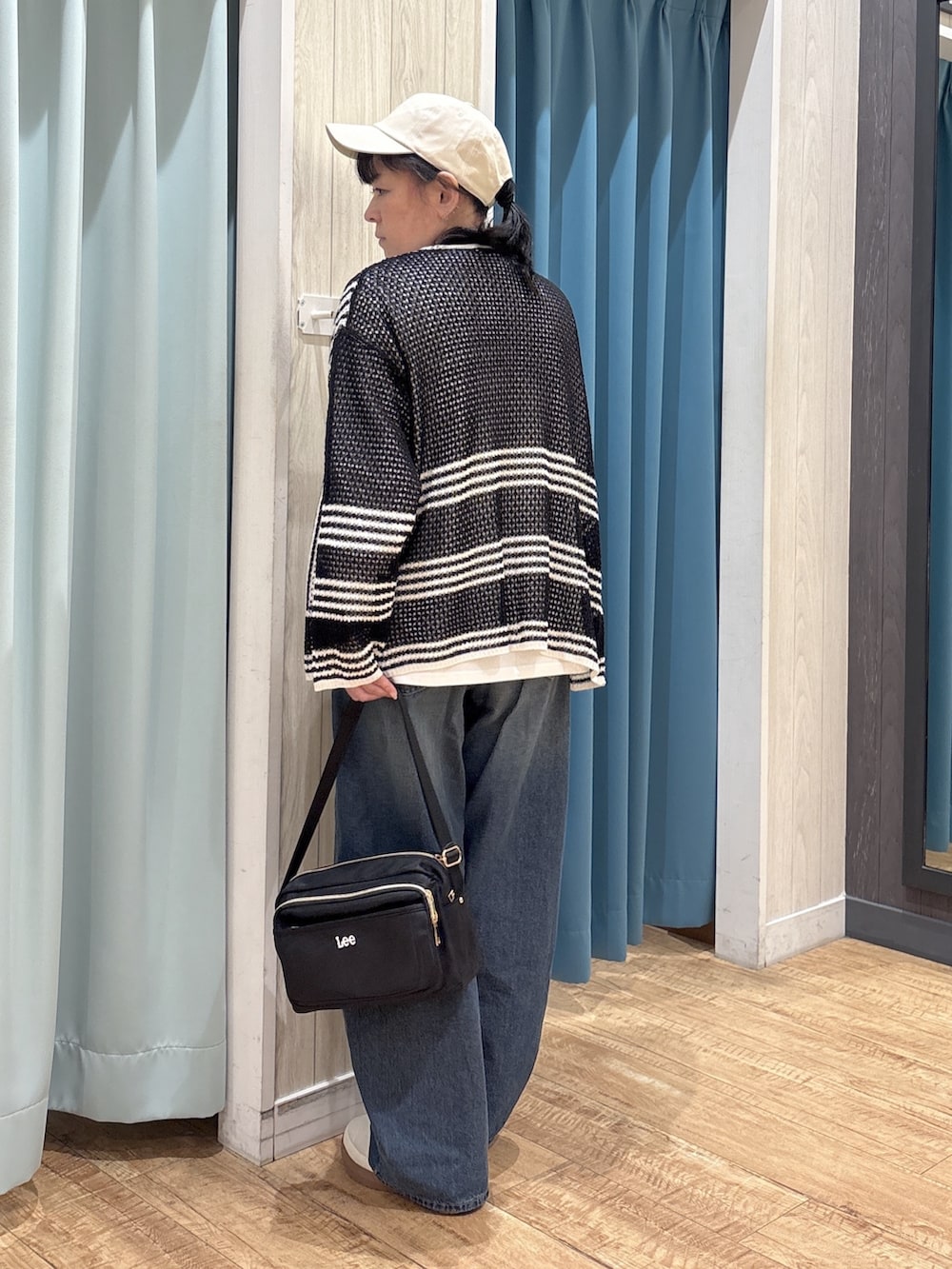 ブラック系のカーディガン/ボレロ、ホワイト系のTシャツ/カットソー、ブルー系のデニムパンツを着用したレディースの春コーディネートの3枚目の写真