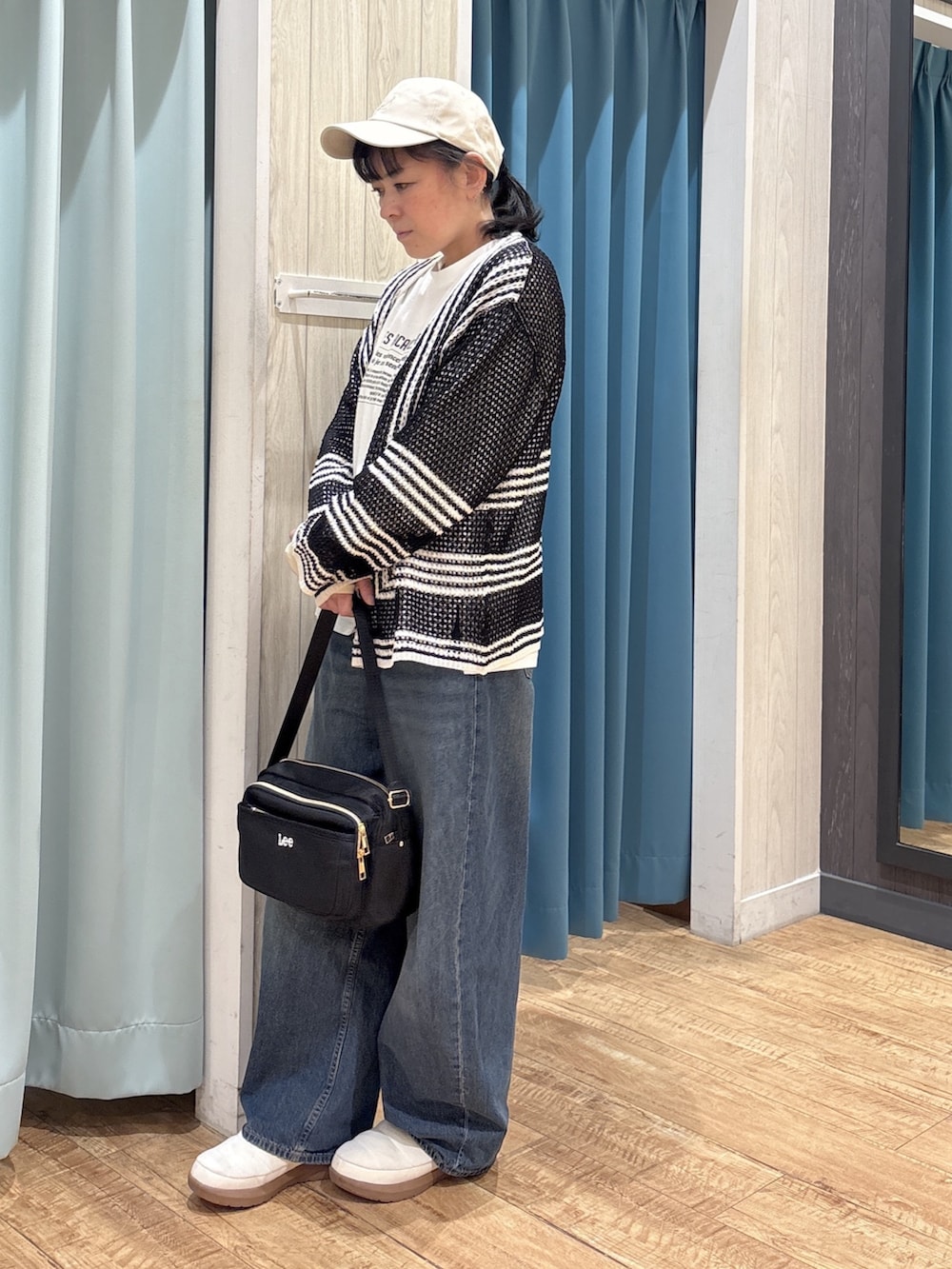 ブラック系のカーディガン/ボレロ、ホワイト系のTシャツ/カットソー、ブルー系のデニムパンツを着用したレディースの春コーディネートの2枚目の写真