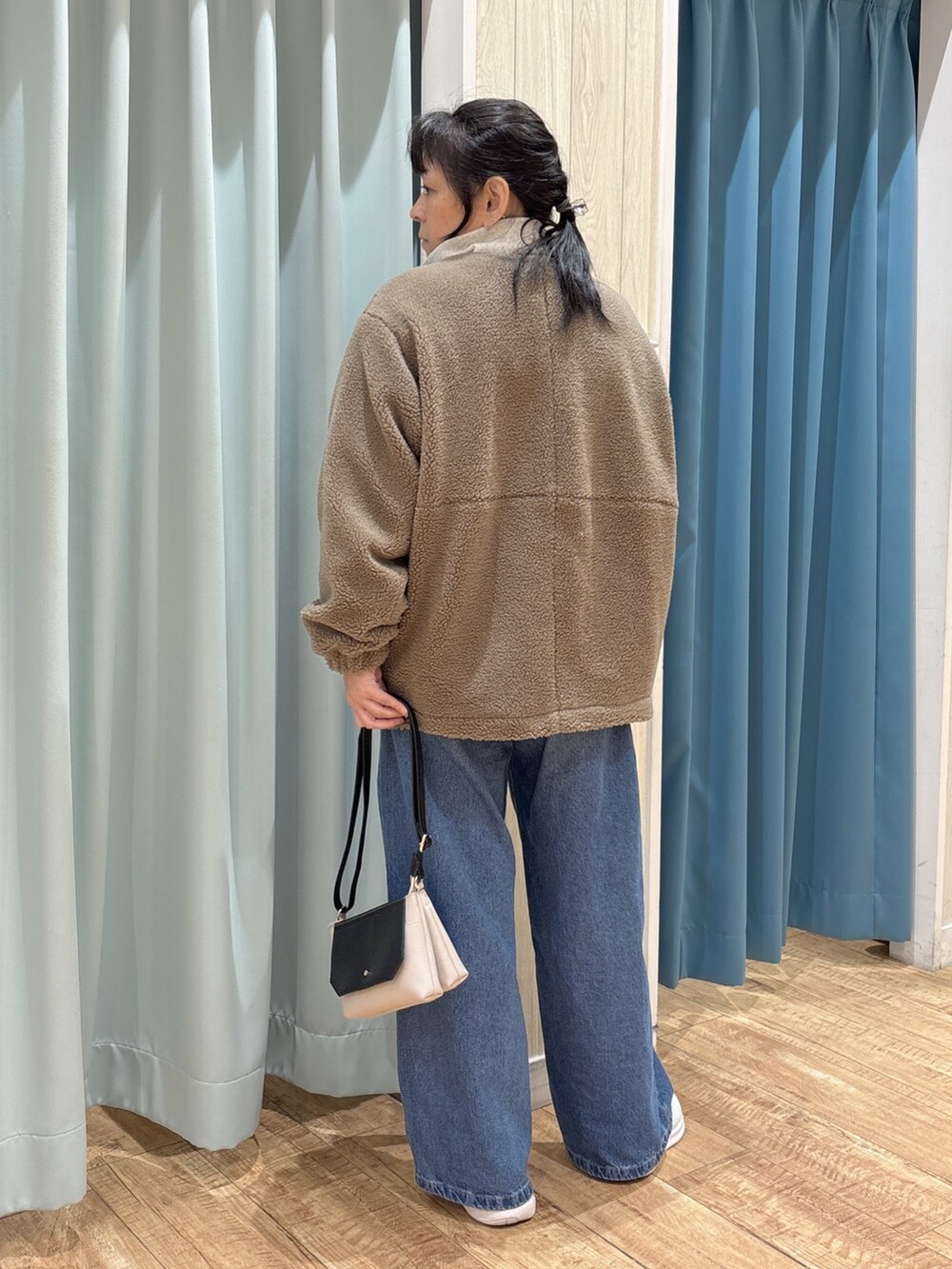 ブラウン系のブルゾン、ブラウン系のTシャツ/カットソー、ホワイト系のスウェットを着用したレディースの秋コーディネートの3枚目の写真