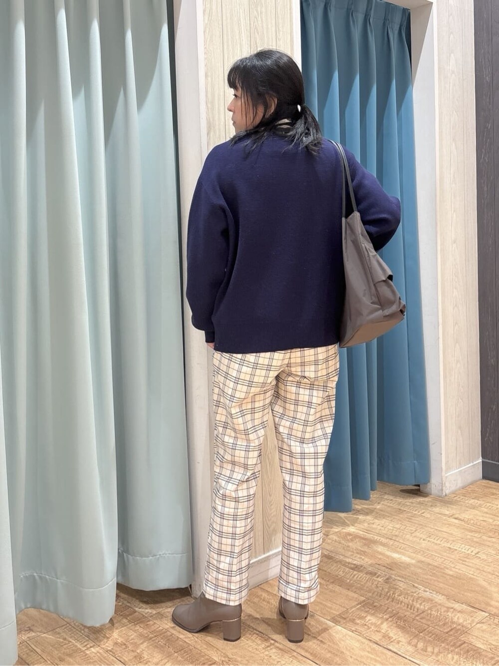 ブルー系のニット/セーター、ベージュ系のTシャツ/カットソー、グレー系のその他パンツを着用したレディースの冬コーディネートの3枚目の写真