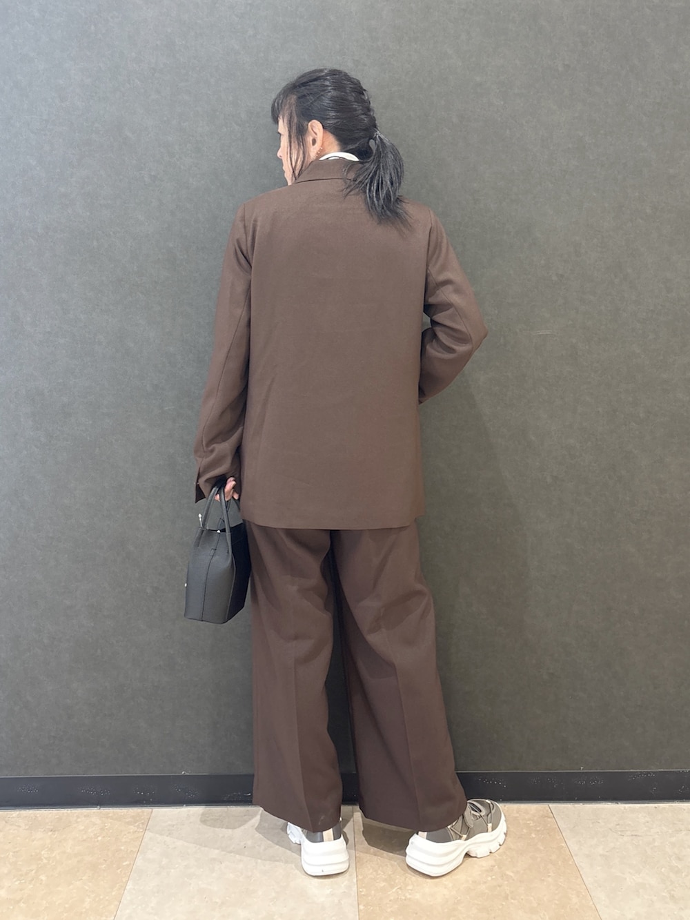 ブラウン系のテーラードジャケット、ブラック系のTシャツ/カットソー、ブラウン系のその他パンツを着用したレディースの秋コーディネートの3枚目の写真