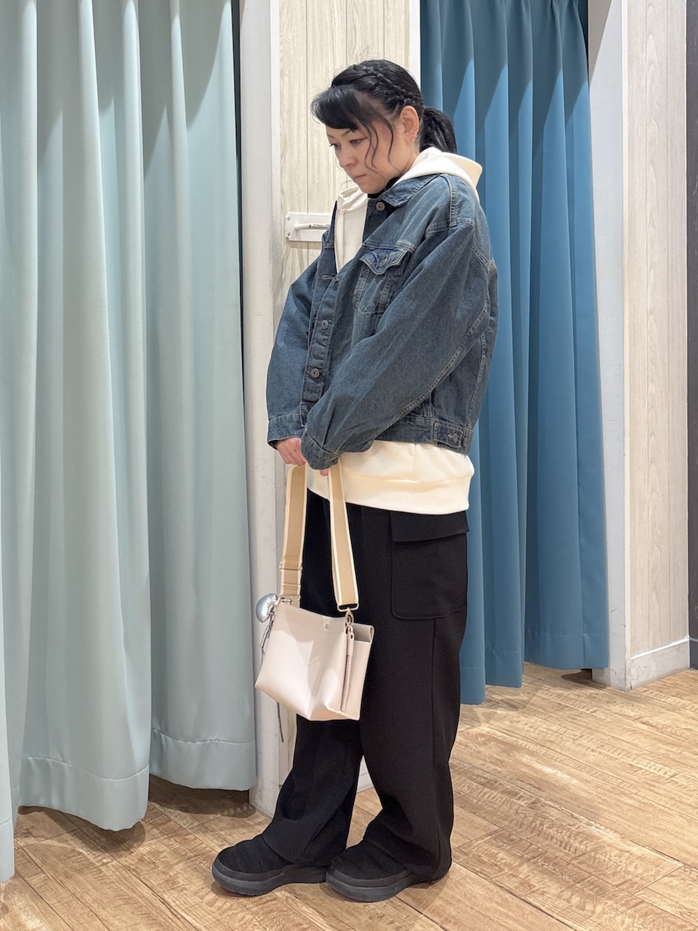 ブルー系のデニムジャケット、ホワイト系のパーカー、ブラック系のTシャツ/カットソーを着用したレディースの冬コーディネートの2枚目の写真