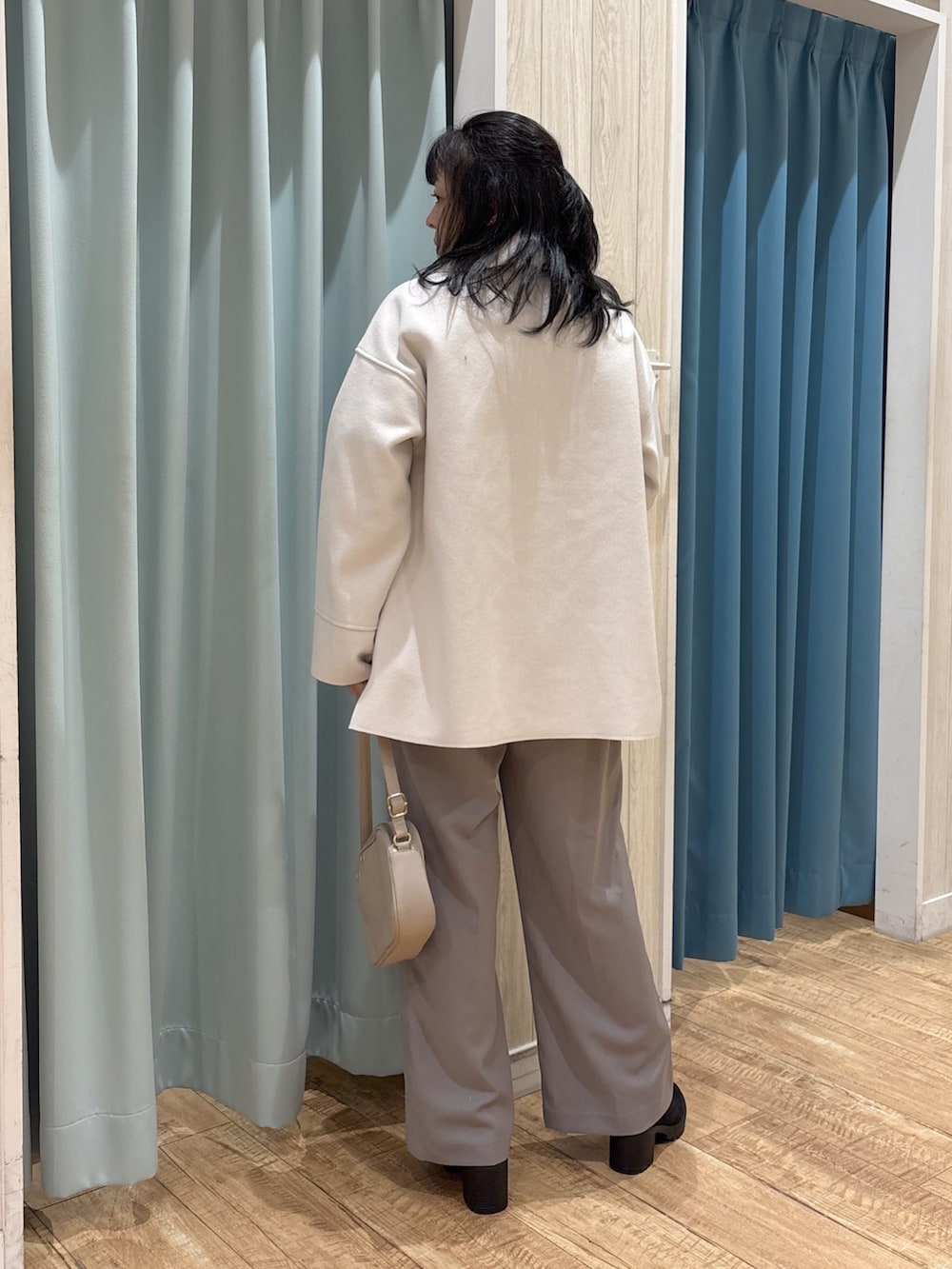 ホワイト系のテーラードジャケット、グリーン系のニット/セーター、グレー系のその他パンツを着用したレディースの秋コーディネートの3枚目の写真