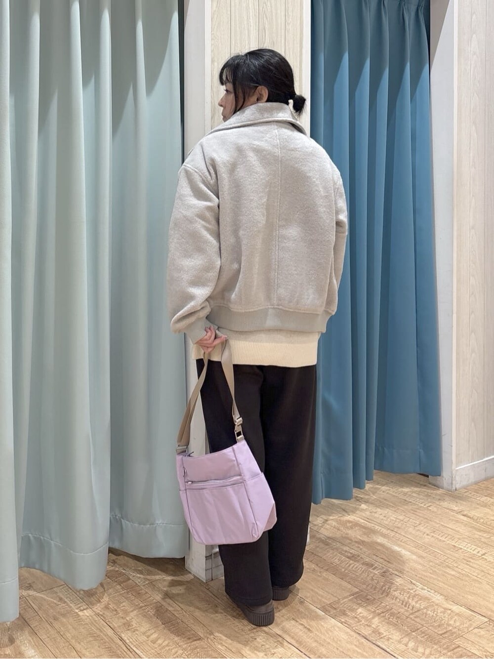 グレー系のブルゾン、ホワイト系のニット/セーター、ブラック系のTシャツ/カットソーを着用したレディースの冬コーディネートの3枚目の写真