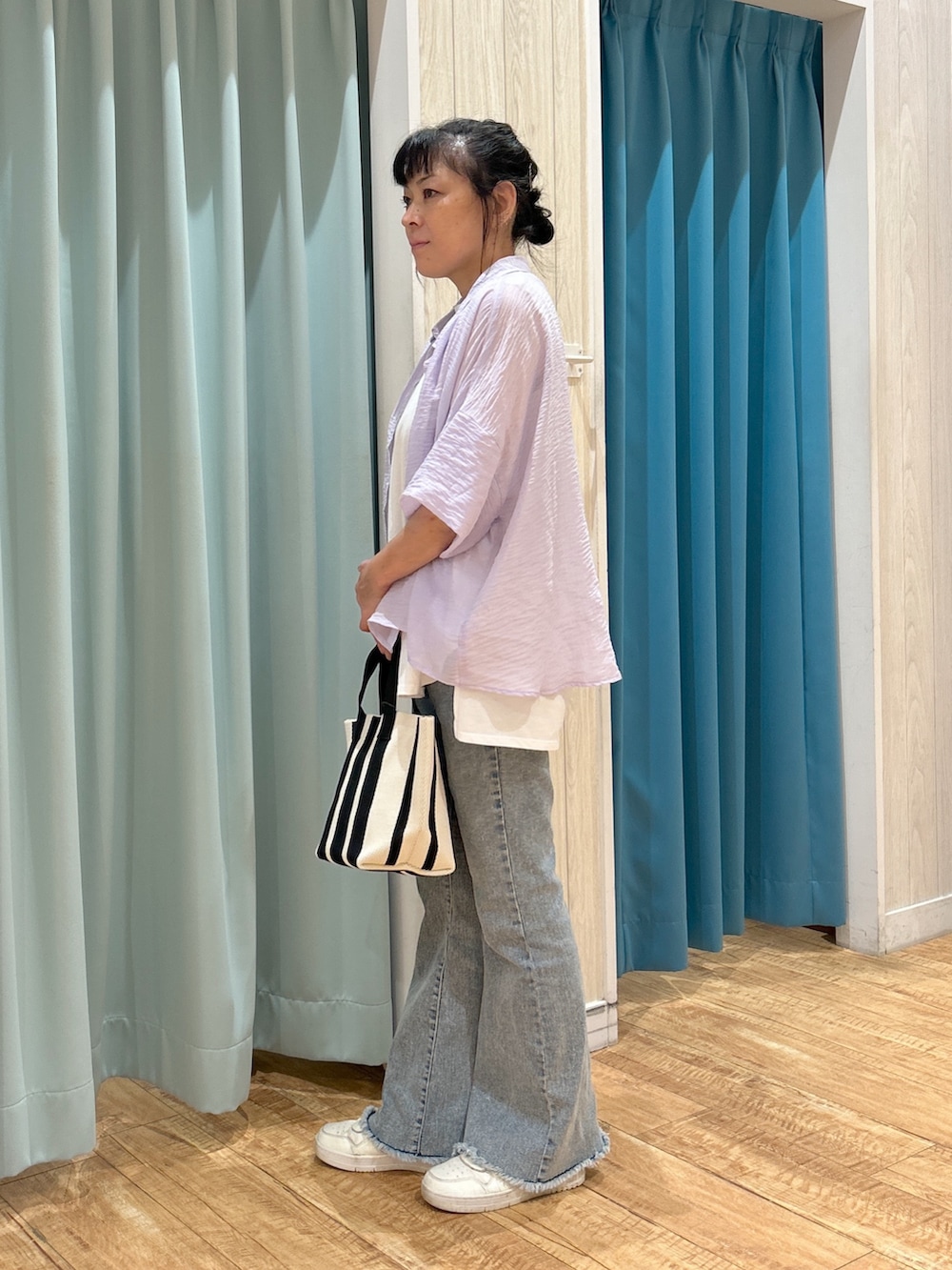 パープル系のシャツ/ブラウス、ホワイト系のチュニック、ブルー系のデニムパンツを着用したレディースの夏コーディネートの2枚目の写真