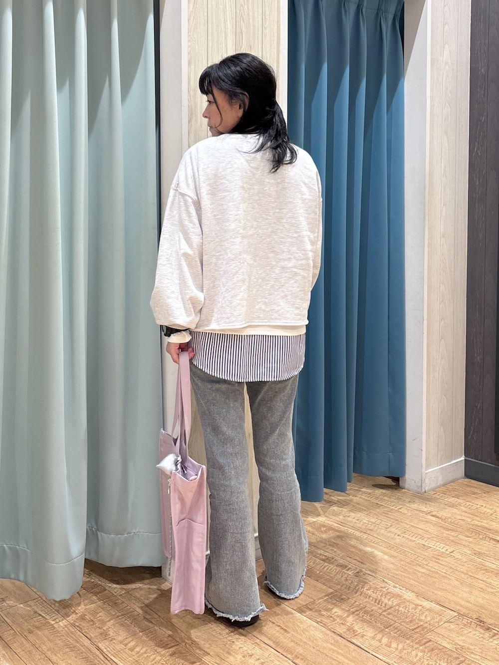 グレー系のスウェット、ホワイト系のTシャツ/カットソー、パープル系のトートバッグを着用したレディースの冬コーディネートの3枚目の写真