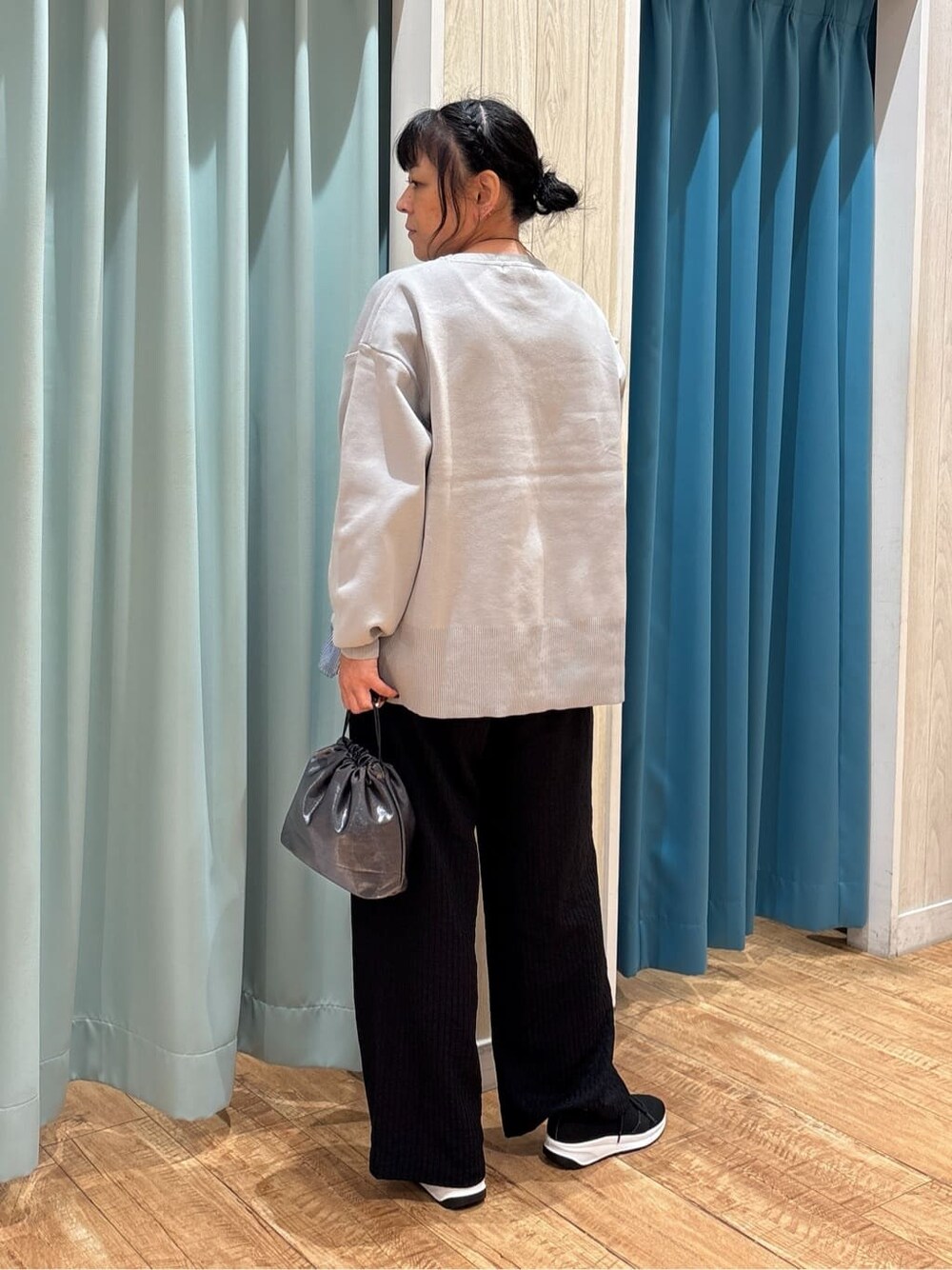 グレー系のニット/セーター、ブラック系のその他パンツ、ブラック系のスニーカーを着用したレディースの秋コーディネートの3枚目の写真