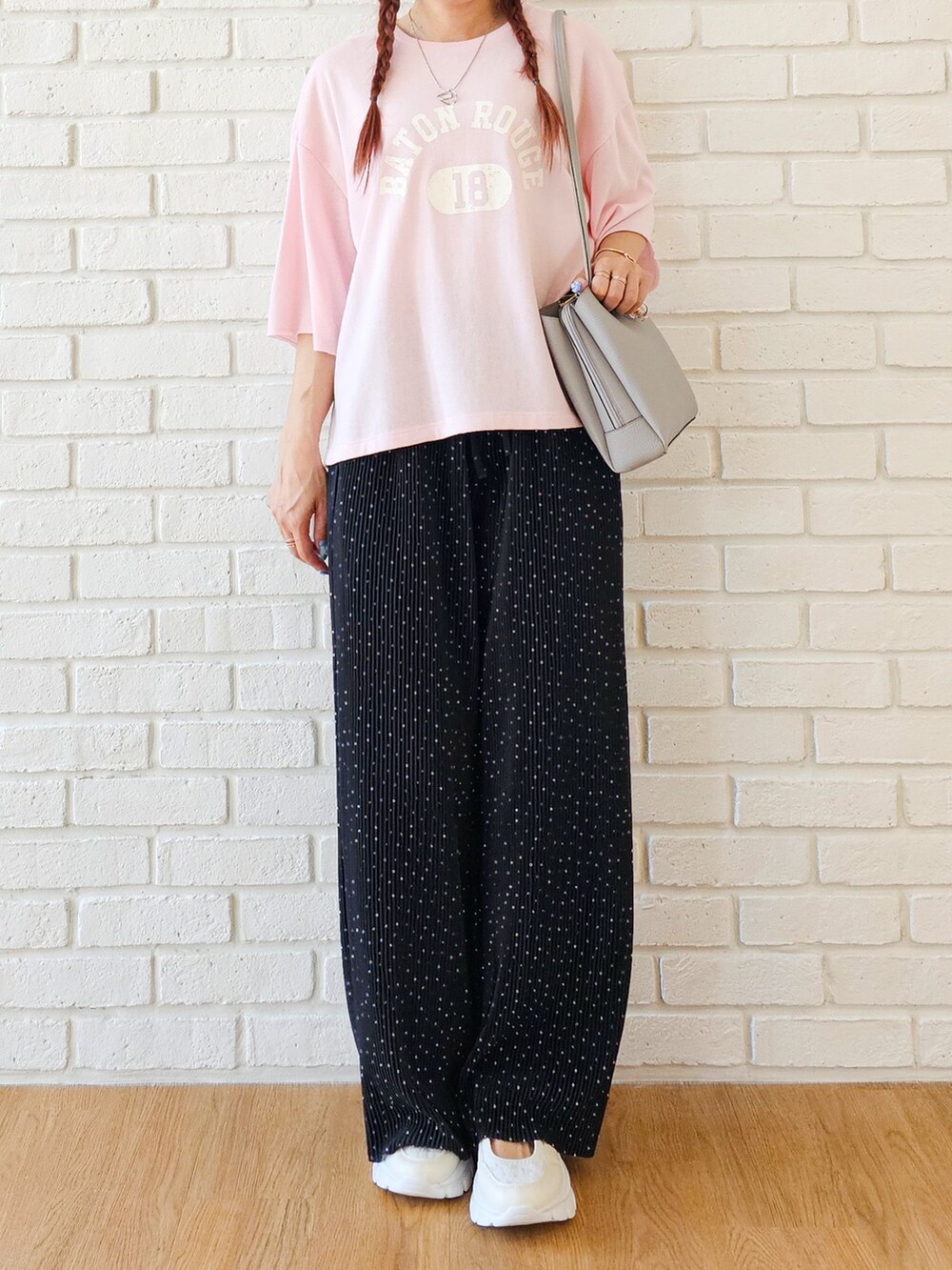ピンク系のTシャツ/カットソー、ブラック系のその他パンツ、ホワイト系のスニーカーを着用したレディースの春コーディネートの5枚目の写真