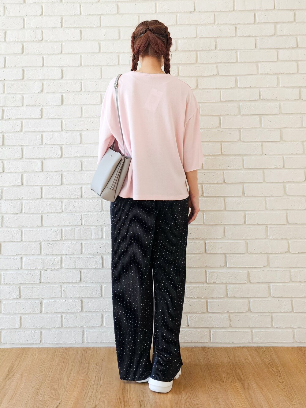 ピンク系のTシャツ/カットソー、ブラック系のその他パンツ、ホワイト系のスニーカーを着用したレディースの春コーディネートの3枚目の写真