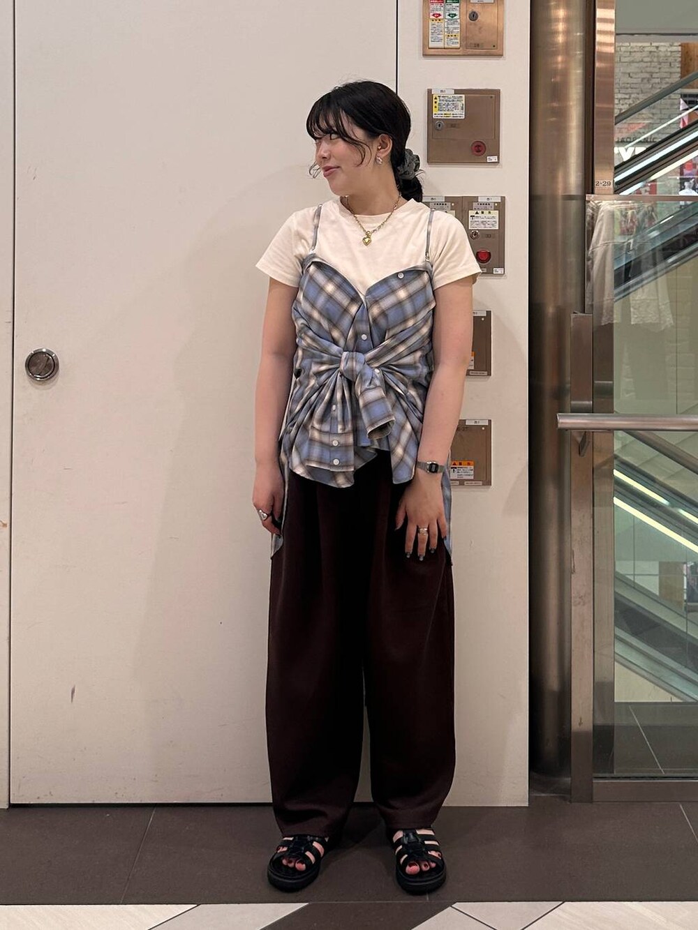 ブラウン系のスウェットパンツ、ブラック系のサンダル、ブラウン系のTシャツ/カットソーを着用したレディースの夏コーディネートの3枚目の写真