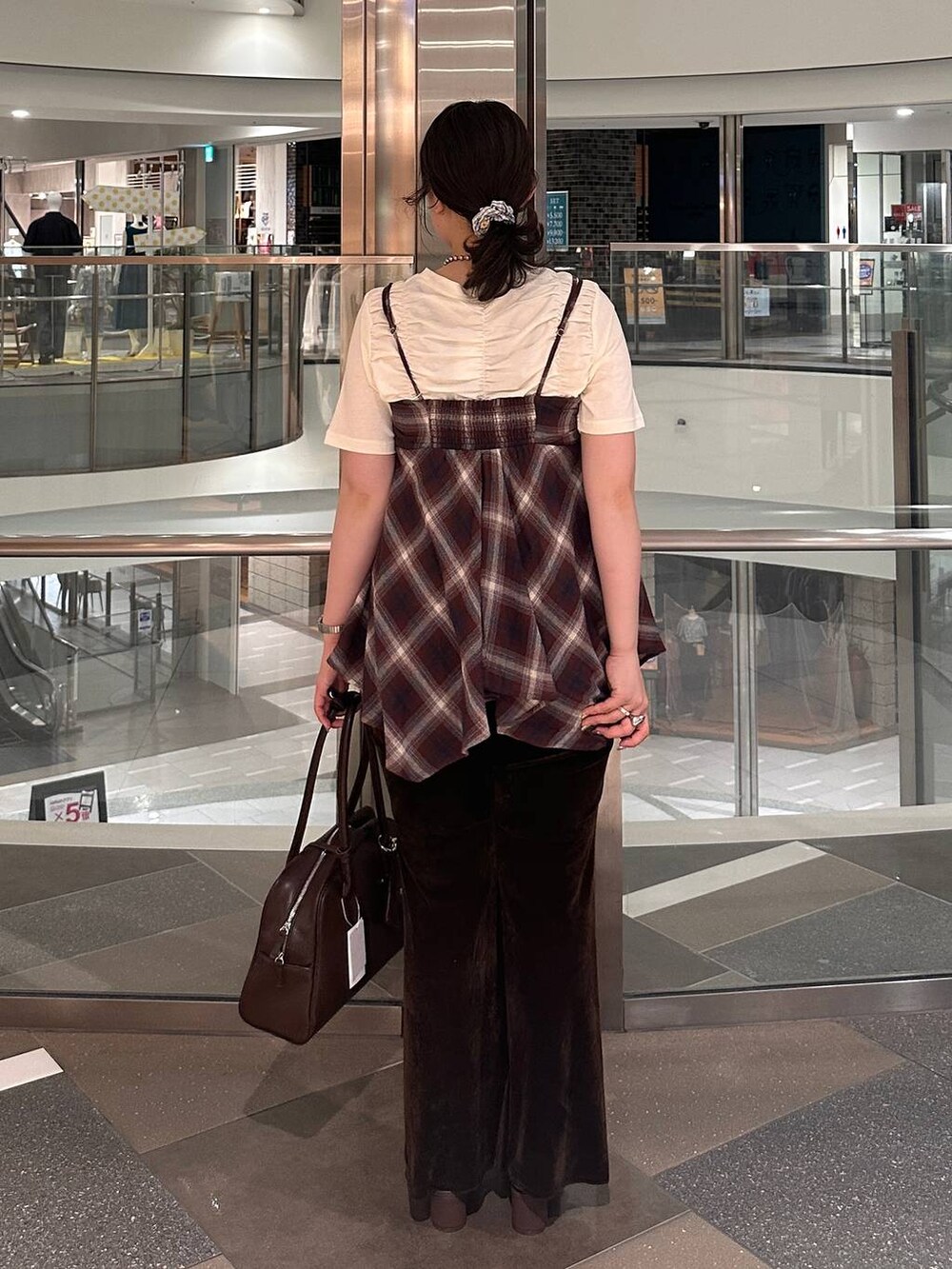 ブラウン系のサンダル、ブラウン系のボストンバッグ、レッド系のTシャツ/カットソーを着用したレディースの夏コーディネートの4枚目の写真