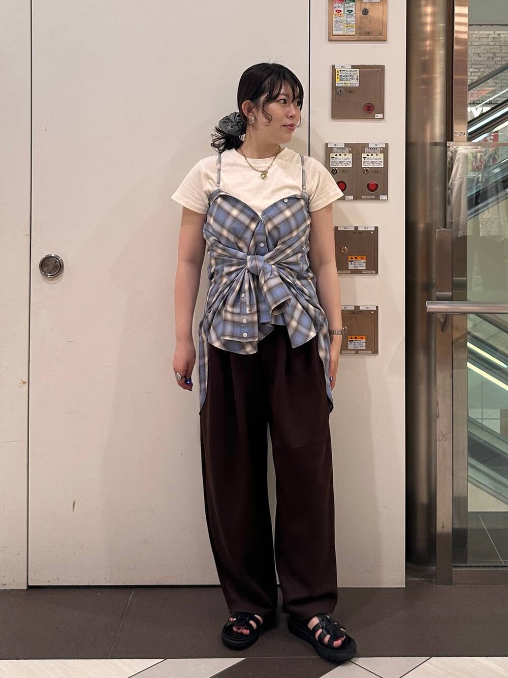 ブラウン系のスウェットパンツ、ブラック系のサンダル、ブラウン系のTシャツ/カットソーを着用したレディースの夏コーディネートの2枚目の写真