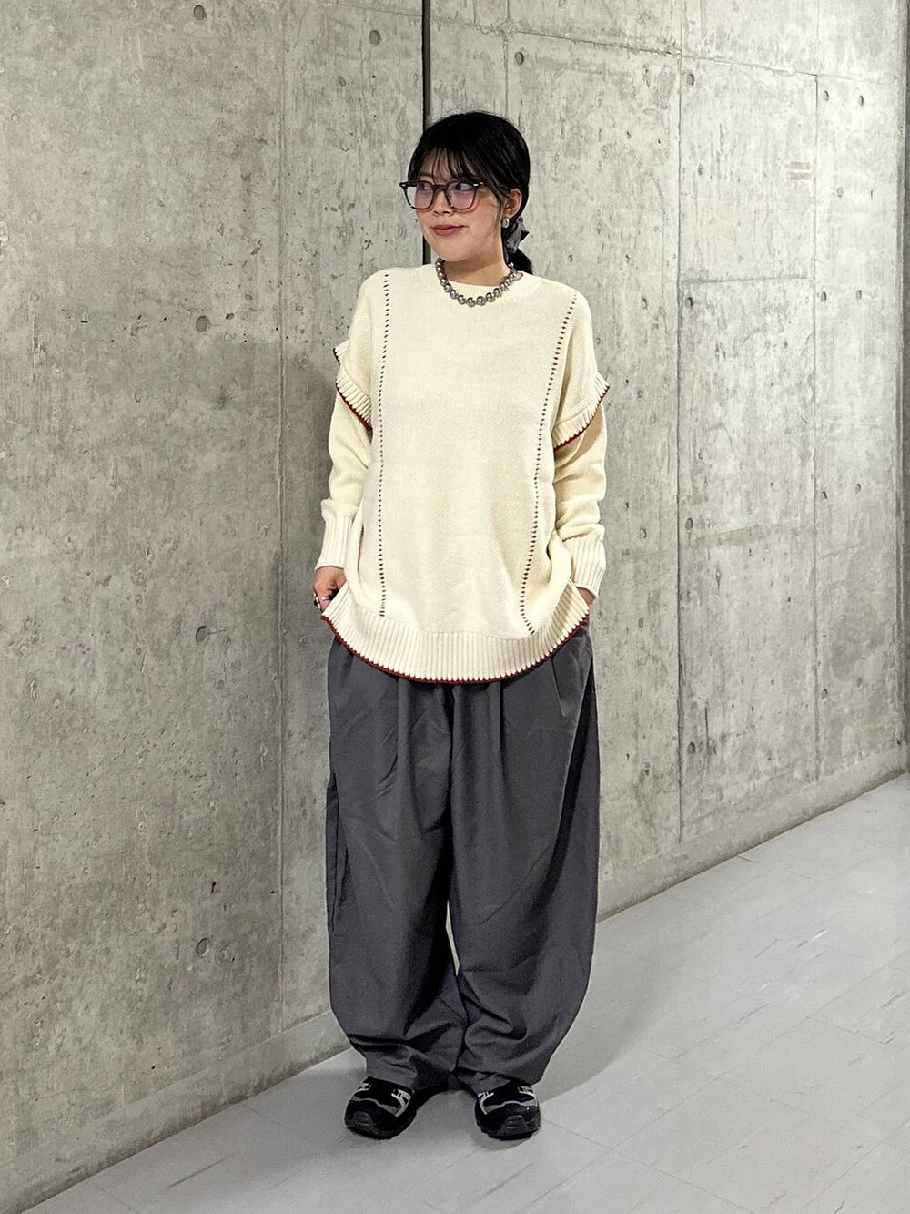 グレー系のその他パンツ、ホワイト系のニット/セーターを着用したレディースの秋コーディネートの3枚目の写真