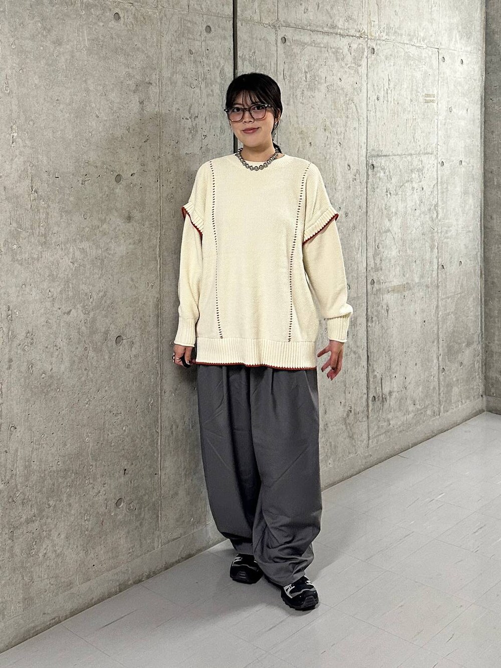 グレー系のその他パンツ、ホワイト系のニット/セーターを着用したレディースの秋コーディネートの2枚目の写真