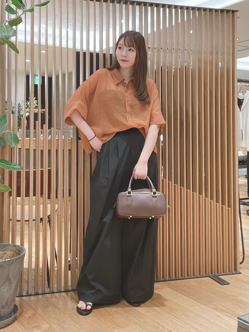 ブラウン系のシャツ/ブラウス、ブラック系のその他パンツ、ブラウン系のハンドバッグを着用したレディースの春コーディネートの2枚目の写真