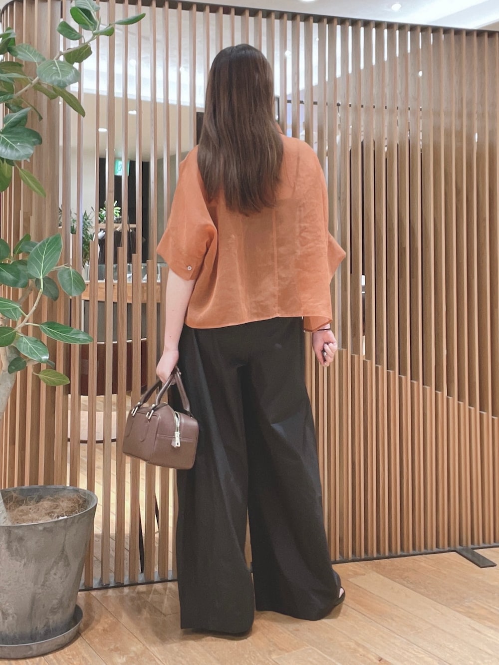 ブラウン系のシャツ/ブラウス、ブラック系のその他パンツ、ブラウン系のハンドバッグを着用したレディースの春コーディネートの4枚目の写真