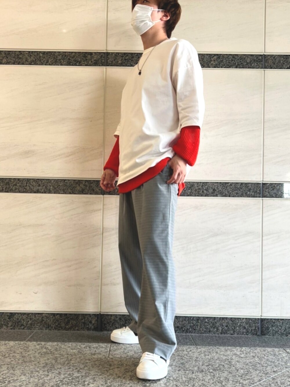 ホワイト系のスニーカー、グレー系のパンツ、オレンジ系のニット/セーターを着用したメンズの春コーディネートの2枚目の写真