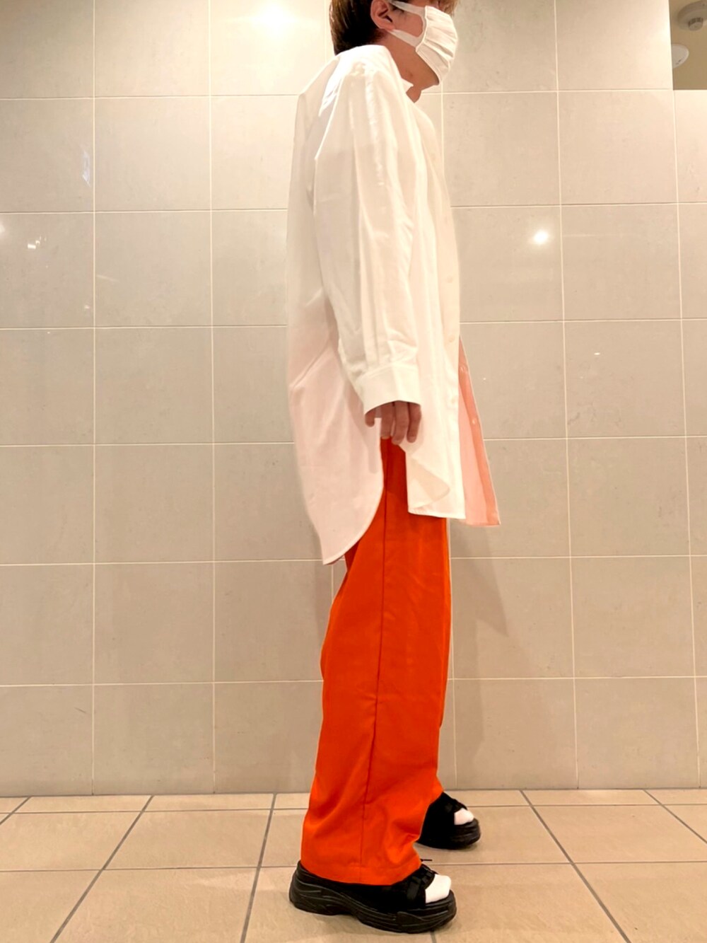 ブラック系のサンダル、オレンジ系のチノパンツ、ホワイト系のシャツ/ブラウスを着用したメンズの春コーディネートの2枚目の写真