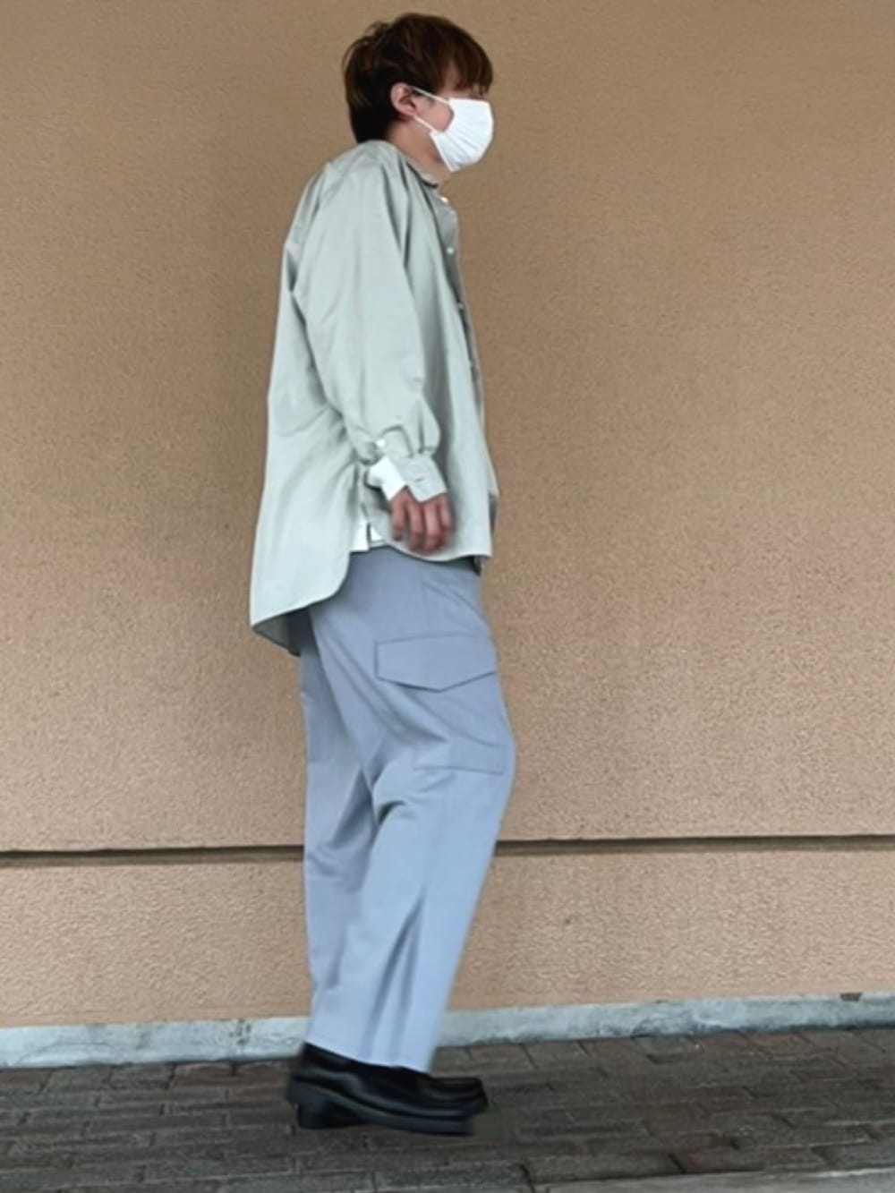 ブラック系のシューズ、グレー系のスラックス、ブラック系のショルダーバッグを着用したメンズの春コーディネートの2枚目の写真