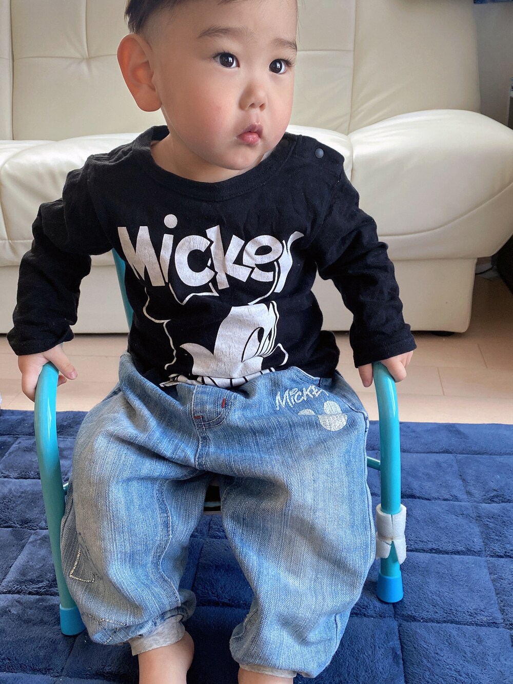 ブラック系のトップス、ブルー系のデニムパンツを着用したレディースの春コーディネートの2枚目の写真