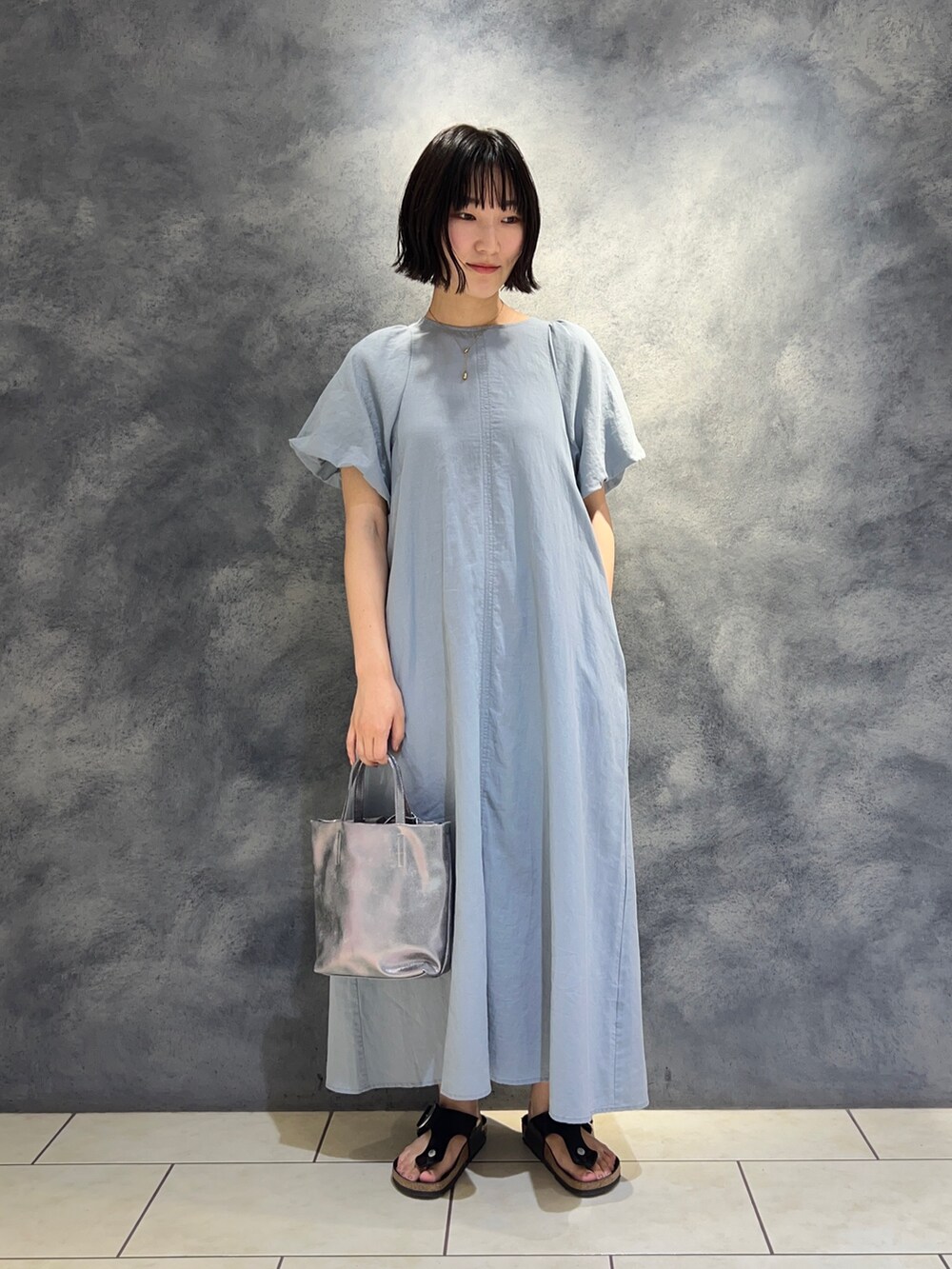 ブルー系のワンピース、シルバー系のショルダーバッグを着用したレディースの夏コーディネートの3枚目の写真