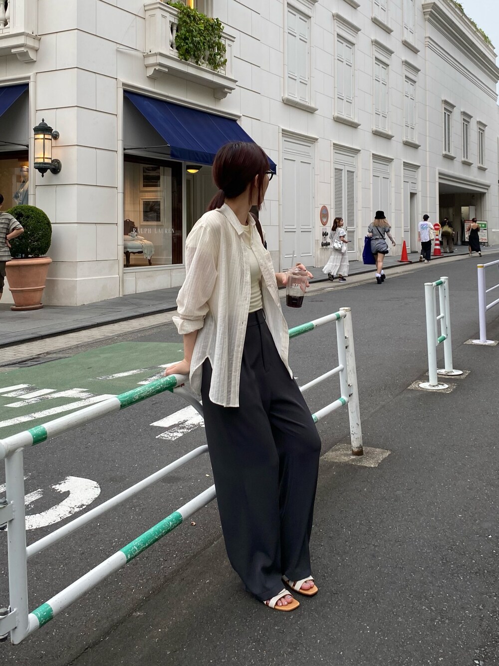 ブラック系のスラックス、ホワイト系のシャツ/ブラウス、ブラウン系のショルダーバッグを着用したレディースの夏コーディネートの3枚目の写真