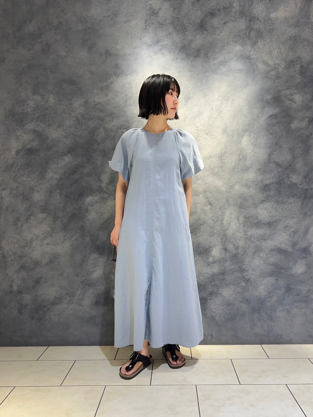 ブルー系のワンピース、シルバー系のショルダーバッグを着用したレディースの夏コーディネートの2枚目の写真