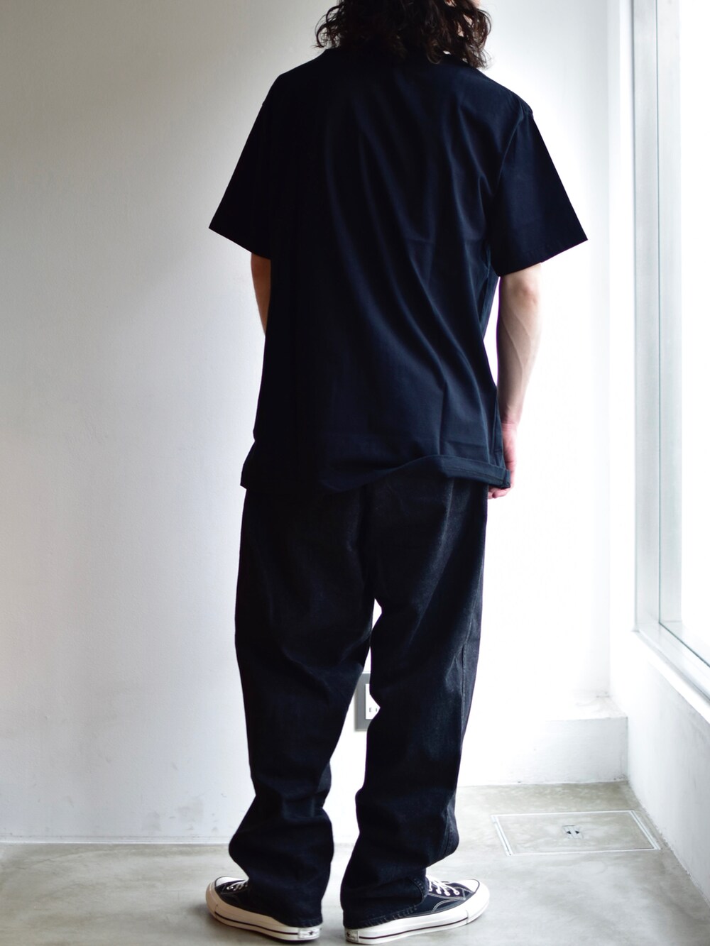 ブラック系のデニムパンツ、ブラック系のTシャツ/カットソーを着用したメンズの秋コーディネートの2枚目の写真