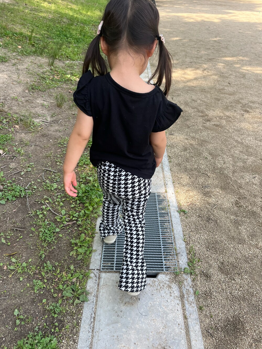 ブラック系のスラックス、ブラック系のタンクトップを着用したキッズの春コーディネートの2枚目の写真