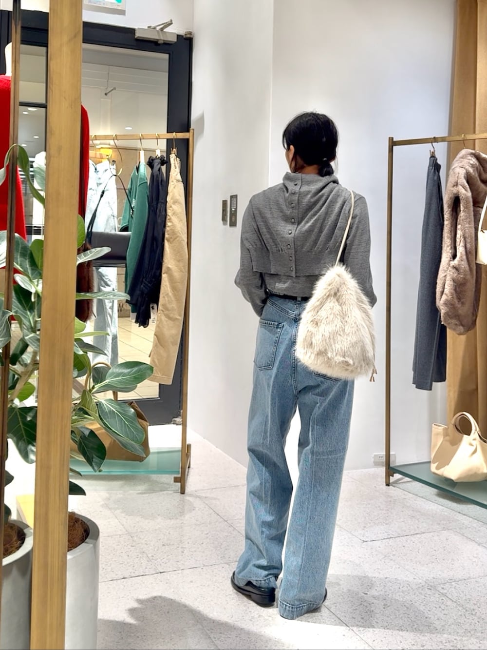 グレー系のカーディガン/ボレロ、グレー系のニット/セーター、ブルー系のデニムパンツを着用したレディースの秋コーディネートの3枚目の写真